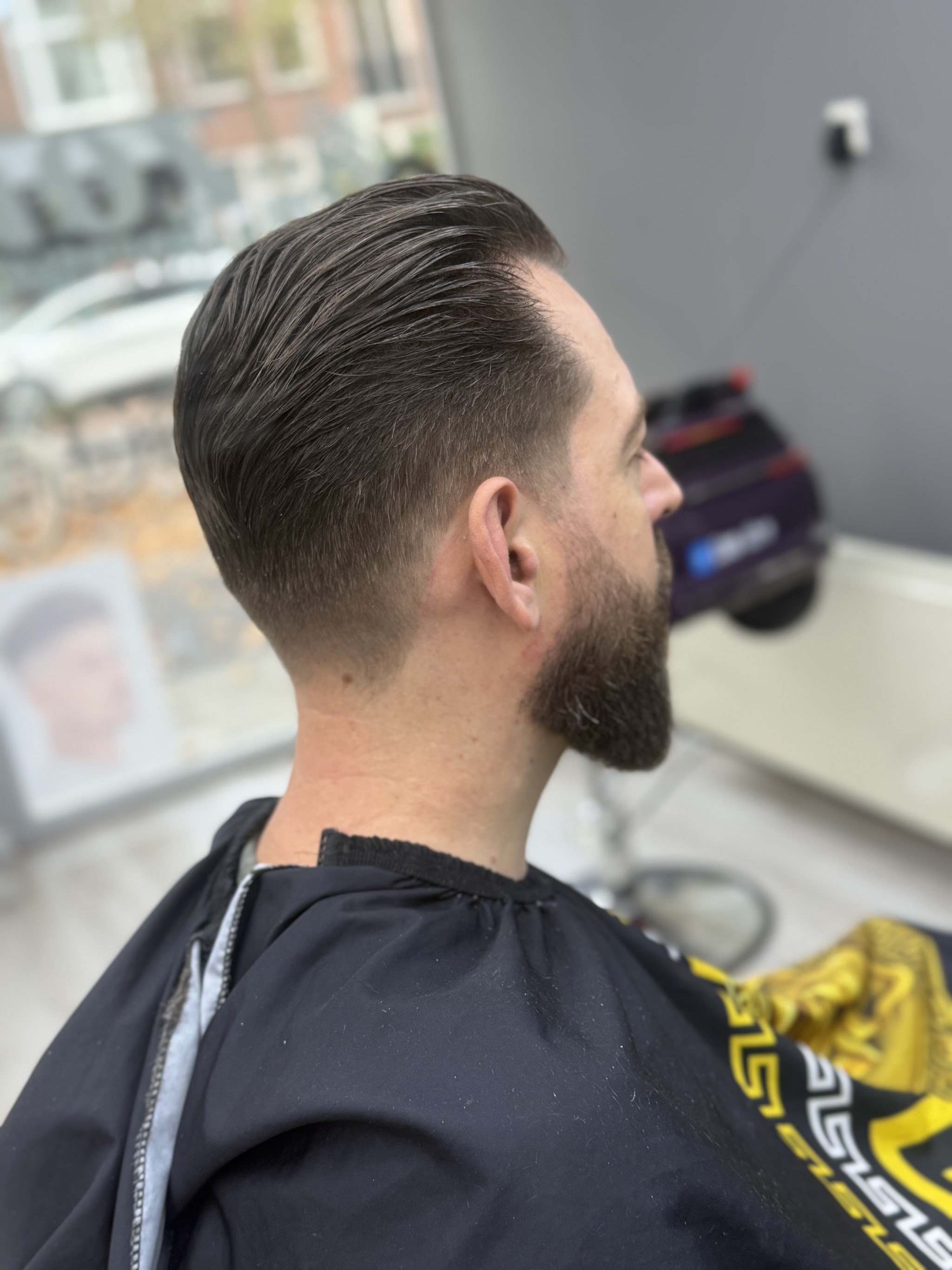 Verzorgde coupe met opgeschoren zijkant en baard