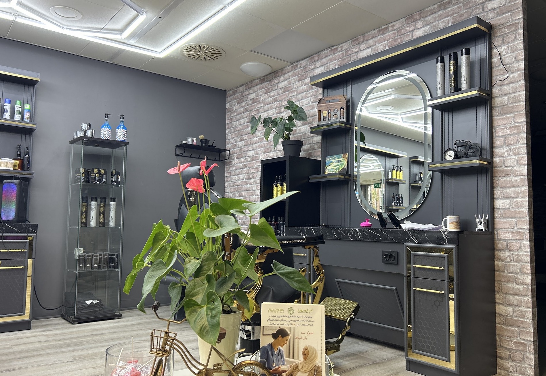 De salon met ronde spiegels, donkere kappersmeubels en verlichte plafonddetails